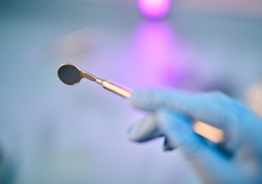 Hand holding dental instrument