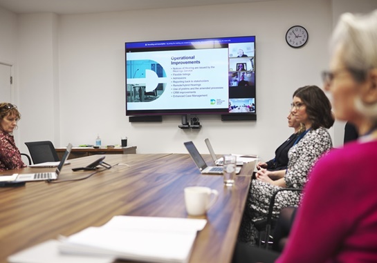 Council members sitting around a table in a meeting