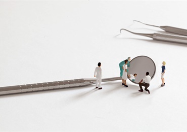 miniature people looking in a mirror